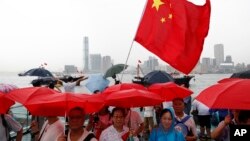 香港警方的支持者2019年7月20日手举红色雨伞和中国国旗在香港举行反示威。