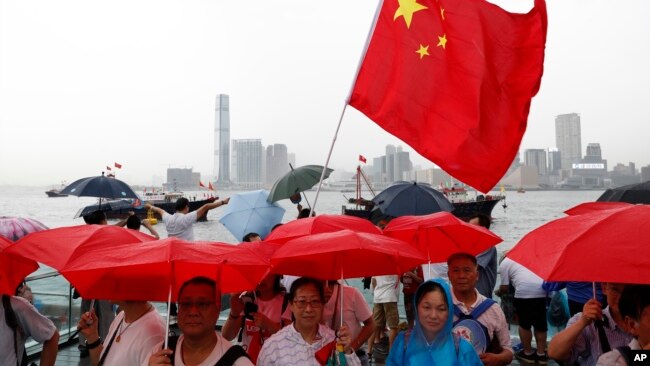 香港警方的支持者2019年7月20日手举红色雨伞和中国国旗在香港举行反示威。