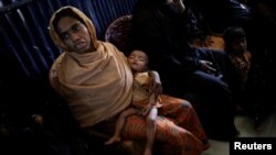 A Rohingya refugee waits for her baby to be examined by doctors at the UNICEF health center at the Kutupalong refugee camp near Cox's Bazar, Bangladesh, Dec. 12, 2017. 
