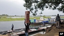 A returnee from North Sudan unloads belonging from a ship in a port of White Nile river in Juba, South Sudan, July 2011. (file photo)