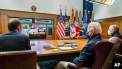 In this photo released by The White House, President Joe Biden, center, meets virtually with his national security team and senior officials to discuss Russia's aggressive actions toward Ukraine, Jan. 22, 2022, at Camp David, Md.