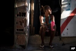 Leticia Miranda sits at her doorstep in the former Brazilian Institute of Geography and Statistics (IBGE) building