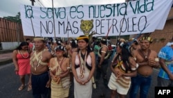 Waorani indigenous people march toward the provincial court to demand the non-exploitation of oil in their territory with a banner reading "The forest is our life. No more oil," in Puyo, Ecuador, April 11, 2019.