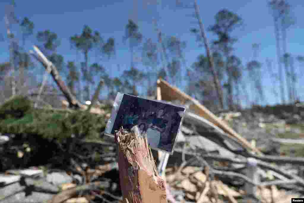 A family photograph sits on the remains of a tree outside a destroyed home after two deadly back-to-back tornadoes, in Beauregard, Alabama, U.S., March 5, 2019.