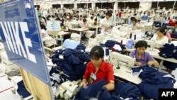 Vietnamese workers work at a sportswear production line for Nike at the Nha Be garment company in Ho Chi Minh City