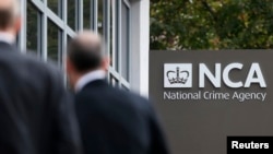 FILE - Pedestrians walk past the National Crime Agency (NCA) headquarters in London October 7, 2013. The new body has been launched to pursue organized criminals.