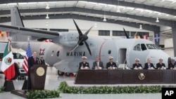 U.S. ambassador to Mexico Earl Anthony Wayne, left, speaks during a ceremony presenting new military equipment for Mexico from the U.S., including the plane behind, at the airport in Mexico City.
