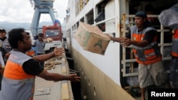 Aid for earthquake and tusnami victims is unloaded from a ship in Palu, Central Sulawesi, Indonesia, Oct. 9, 2018. 