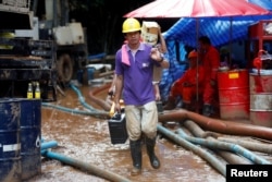 Rescue workers come out from the Tham Luang cave complex in the northern province of Chiang Rai, Thailand, July 3, 2018.