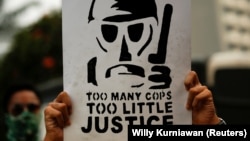 Seorang mahasiswa memegang poster dalam aksi unjuk rasa untuk menentang pelanggaran hak asasi manusia, korupsi dan kasus pencemaran lingkungan di Jakarta pada 28 Oktober 2019. (Foto: Reuters/Willy Kurniawan)
