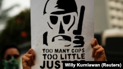 Seorang mahasiswa memegang poster dalam aksi unjuk rasa untuk menentang pelanggaran hak asasi manusia, korupsi dan kasus pencemaran lingkungan di Jakarta pada 28 Oktober 2019. (Foto: Willy Kurniawan/Reuters)