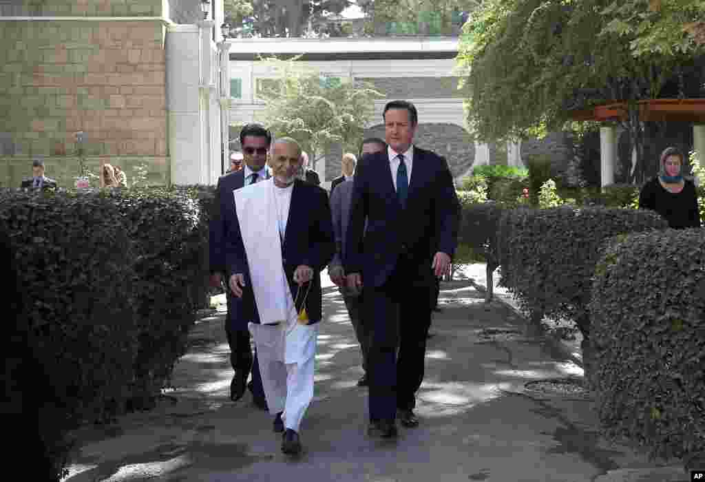 Afghanistan's president Ashraf Ghani Ahmadzai and Britain's Prime Minister David Cameron arrive for a news conference at the presidential palace in Kabul, Afghanistan, Oct. 3, 2014.