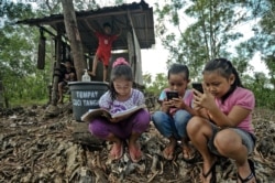 Para pelajar mengikuti kelas daring selama pandemi dengan menggunakan telepon genggam dengan akses internet yang masih terbatas (AFP).