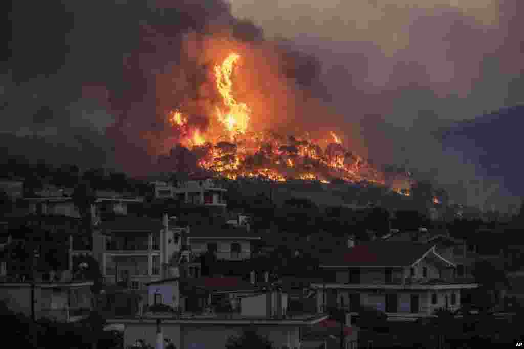 Fire burns near the village of Galataki as authorities evacuate the residents near Corinth, Greece, July 22, 2020.