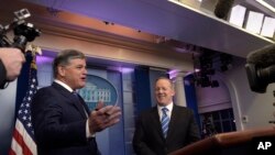 FILE - White House press secretary Sean Spicer, center, is interview by Sean Hannity, left, of Fox News Channel in the briefing room of the White House in Washington, Jan. 24, 2017.