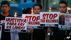 FILE - Protesters hold placards in a candlelit protest against extrajudicial killings in President Rodrigo Duterte's "War on Drugs" campaign in suburban Quezon city, northeast of Manila, Philippines, Oct. 8, 2016.