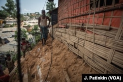 Soyet Alum stands by his home in the Bulukhali refugee camp, where he fears rains will rash away the sand beneath his hut. The upcoming rainy season increases the risk of landslides. Small landslides have already killed several refugees.