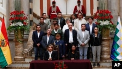 La presidenta interina de Bolivia, Jeanine Añez, a la izquierda, se sienta al lado de la presidenta del Senado, Monica Eva Copa, para promulgar una ley para celebrar nuevas elecciones en La Paz, Bolivia.