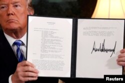 FILE - U.S. President Donald Trump holds up a proclamation declaring his intention to withdraw from the JCPOA Iran nuclear agreement after signing it in the Diplomatic Room at the White House in Washington, May 8, 2018.