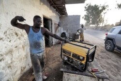 Seorang teknisi tengah memperbaiki genset di luar sebuah toko di Tripoli, Libya, 26 Agustus 2021.