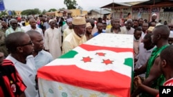 FILE - In this Sunday, May 24, 2015 file photo, men carry the coffin of UPD-Zigamibanga party leader Zedi Feruzi during his funeral in Bujumbura, Burundi. Independent experts should investigate Burundi forces for alleged human rights violations including extra-judicial executions, rape and looting during the deadliest day in the months of unrest over President Pierre Nkurunziza's extended tenure, an international human rights group has said.