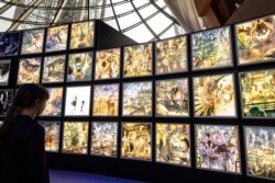 Seorang pengunjung melihat ilustrasi tokoh TV Jepang dan buku terlaris kartunis Akihiro Nishino "Poupelle et la ville sans ciel" selama pameran di Menara Eiffel di Paris, 25 Oktober 2019. (BERTRAND GUAY / AFP)