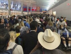In this photo provided by Austin Boschen, people wait in line to go through the customs at Dallas Fort Worth International Airport in Grapevine, Texas, Saturday, March 14, 2020. International travelers reported long lines at the customs at the airport.