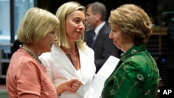EU foreign policy chief Catherine Ashton (R) talks with Italy's Foreign Minister Federica Mogherini (C), and Croatia's Foreign Minister Vesna Pusic, during an EU foreign ministers council at the European Council building in Brussels, July 22, 2014.
