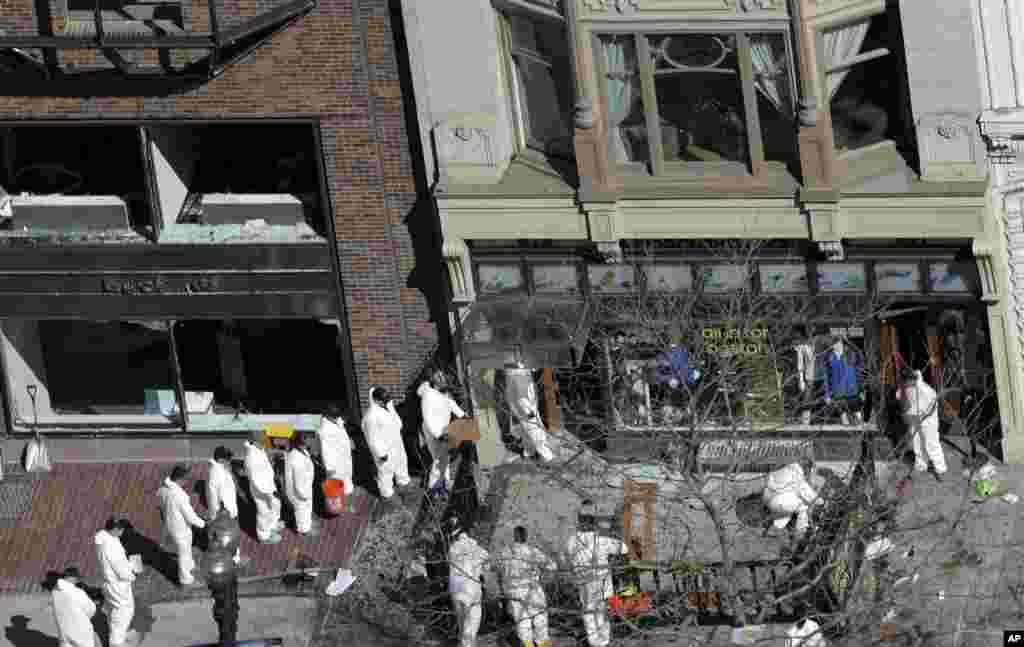 A line of investigators is form as they enter a building adjacent to one of the blast sites near the Boston Marathon finish line, in Boston, April 18, 2013.