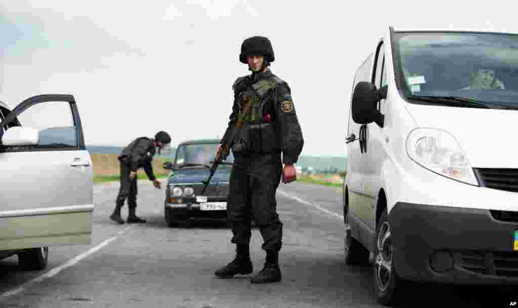 Binh sĩ Ukraine khám xét xe cộ tại một chốt kiểm soát bên ngoài thành phố Slovyansk, miền đông Ukraine.