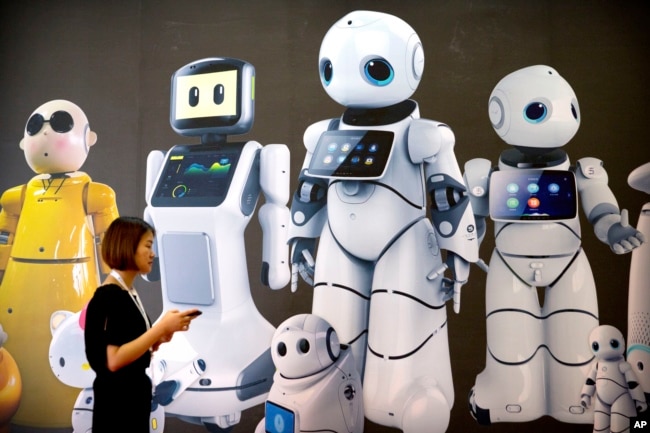 Seorang pengunjung berjalan melewati mural yang menampilkan robot dari pembuat robot China Canbot di Konferensi Robot Dunia di Beijing, Cina, Rabu, 15 Agustus 2018. (Foto: AP)
