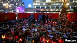 Flowers and candles are placed at the former Christmas market in Berlin, Germany, Jan. 3, 2017, following an attack by a truck in December which plowed through a crowd at the market.