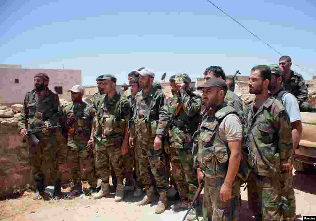 Forces loyal to Syria's President Bashar al-Assad gather in Sheikh Zayyat village, after saying they have regained control of the area, June 26, 2014.