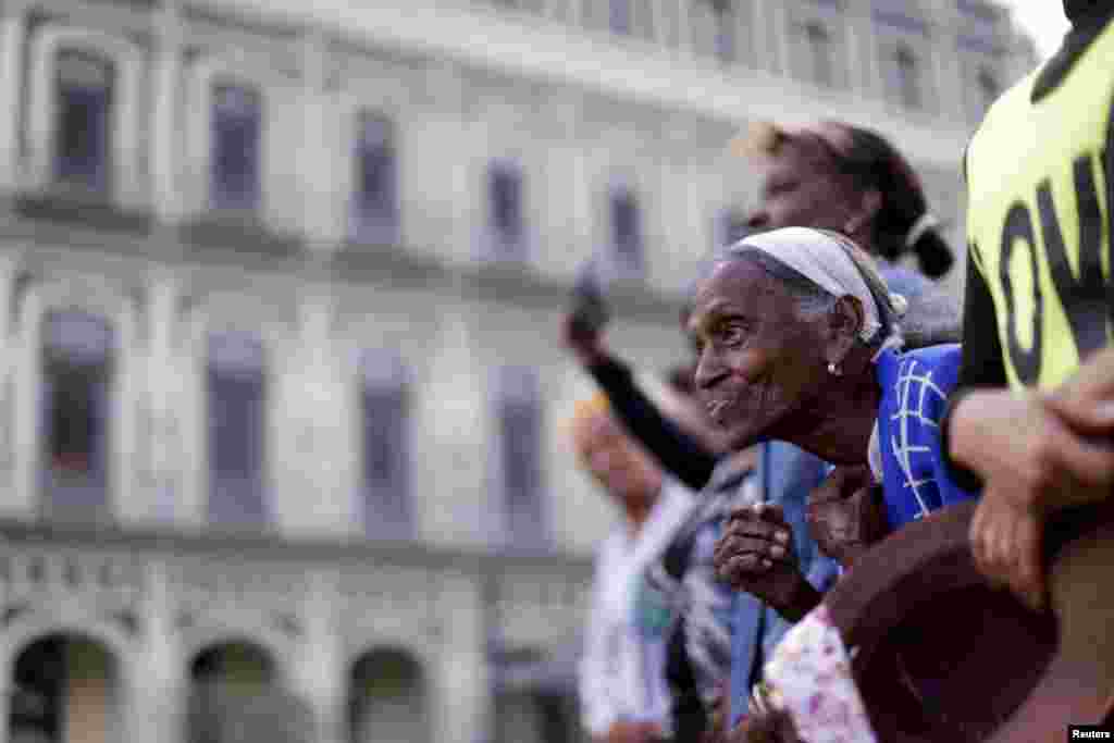 Seorang perempuan lansia bersama warga Kuba lainnya, menunggu kedatangan Presiden AS Barack Obama untuk memberikan pidato di Gran Teatro de la Habana Alicia Alonso di Havana, Kuba.
