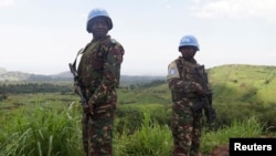 FILE - U.N. peacekeepers from Tanzania hold their weapons as they patrol outside Goma during a visit by officials from the U.N. Security Council in the eastern Democratic Republic of Congo, October 2013.