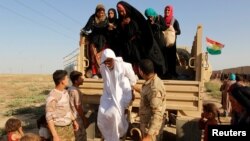 Kurdish Peshmerga forces help people from Sunni Muslims, who fled the Islamic State's strongholds of Hawija, as they arrive on the outskirts of Kirkuk, Iraq, August 21, 2016. 