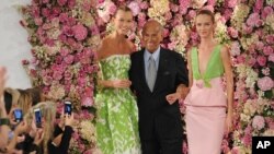 Oscar de la Renta saluda junto a las modelos Karlie Kloss (izquierda) y Daria Strokous, tras la presentación de su colección de Primavera 2015 en Nueva York.