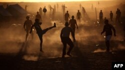 Men, who used to work in Libya and fled the unrest in the country, play football in a refugee camp at the Tunisia-Libyan border, in Ras Ajdir, Tunisia, Thursday, March 17, 2011. More than 250,000 migrant workers have left Libya for neighboring countries, 