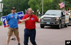 FILE - Minnesota congressional candidates, Democrat Dan Feehan (L) and Republican Jim Hagedorn, work a parade in Waterville, Minnesota, June 10, 2018.