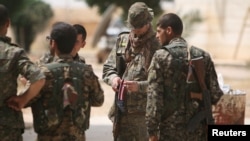 Binh sĩ thuộc lực lượng đặc biệt Mỹ và Lực lượng Dân chủ Syria (SDF) ở thị trấn miền nam Raqqa, Syria, ngày 27/5/2016.