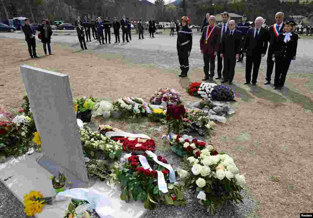 French Interior Minister Bernard Cazeneuve (C), Le Vernet Mayor Francois Balique (5thR), Prefect of the Alpes de Haute-Provence region, Patricia Willaert (R) and President of the Var departmental council, Michel Vauzelle (3rdR), spend a moment of silence after laying a wreath in memory of the victims of the Germanwings Airbus A320 crash, in the village of Le Vernet, French Alps.