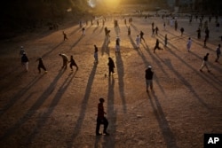 In this Jan. 27, 2015, photo, Pakistani students of a madrassa play football in their seminary's yard as the sun sets on the outskirts of Islamabad, Pakistan.
