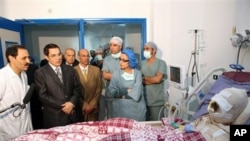 In this photo released 28 Dec 2010 by the Tunisian President's office, Tunisia's President Zine El Abidine Ben Ali, second from left, visits Mohamed Bouazizi, a young man who set himself on fire after police confiscated fruit and vegetables he sold withou