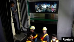 Para penumpang dari arah yang berlawanan, mengamati kerusakan pada kereta api bawah tanah (subway) saat para pekerja tengah memeriksanya pasca tabrakan di dekat stasiun Sangwangsimni, sebelah timur kota Seoul, Korea Selatan (2/5).