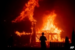 A home burns as the Camp Fire rages through Paradise, Calif., on Nov. 8, 2018.