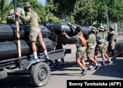 Anggota regu pengintai amfibi laut Indonesia mempersiapkan peralatan untuk operasi pencarian di pelabuhan Tanjungwangi dekat pangkalan angkatan laut di Banyuwangi, Jawa Timur pada 25 April 2021. (Foto: AFP/Sonny Tumbelaka)