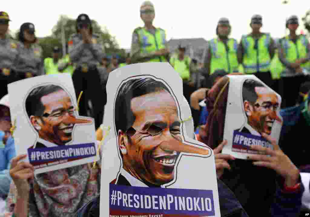 Students wear a mask of Indonesia President Joko Widodo with a long nose, protesting against fuel price increases outside the presidential palace in Jakarta. Widodo announced a sharp increase in fuel prices on Monday, saying costly government subsidies would be better spent on infrastructure and development. &nbsp;