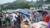 A woman stands with an umbrella next to sacks of rice during a food distribution for internally displaced people (IDP) from Amhara region, in the city of Dessie, Ethiopia, 