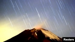 Hujan meteor Geminid menerangi langit di atas gunung berapi Popocatepetl di Meksiko, dekat desa San Nicolas des los Ranchos di negara bagian Puebla, dini hari 14 Desember 2004. Puncak hujan meteor Geminid untuk 2018 diperkirakan pada 13-14 Desember.