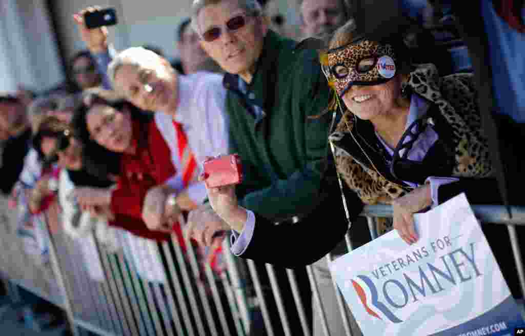 Wearing a mask on Halloween, Carol Heye of Riverview, Florida, shows her support for Mitt Romney as he campaigns in Tampa, Florida.